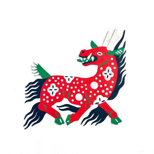 Die cut, brightly painted wooden sculpture of a kirin, a horned horse-like creature with patterning on its body and a wild flowing mane. 