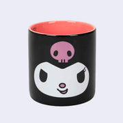 16 oz black mug with orangish pink interior. Exterior has a large graphic of Kuromi's face. 