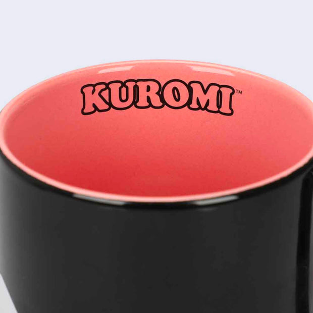 Mug interior, orangish pink and has "kuromi" written on the inner rim.