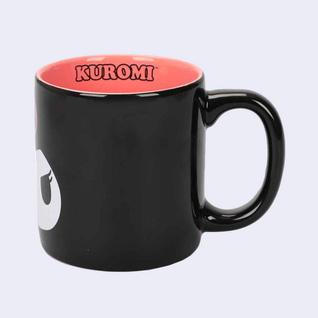 Backside of black 16oz mug. Interior is orangish pink and has "kuromi" written on the inner rim.