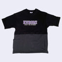 T-shirt, black on top and dark gray on bottom, with purple text that reads "Kuromi" in capital letters in the center. Below, in white text reads "Enjoy the Outdoors"