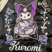 Close up of a large embroidered graphic of Kuromi sitting on a purple rose with more roses and butterflies next to her.