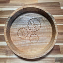 Wooden tray with engraved designs on a wooden surface