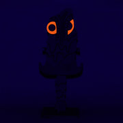 Sculpture of a stylized paddle or sword, modeled to look like Hedorah ink dark gray, orange and red colorings.l
