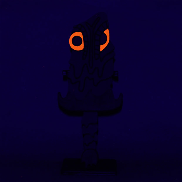 Sculpture of a stylized paddle or sword, modeled to look like Hedorah ink dark gray, orange and red colorings.l