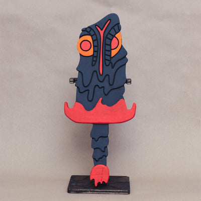 Sculpture of a stylized paddle or sword, modeled to look like Hedorah ink dark gray, orange and red colorings.l
