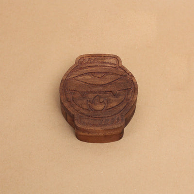 Die cut wooden box, shaped like a lantern with a partially opened eye and mouth with fangs.