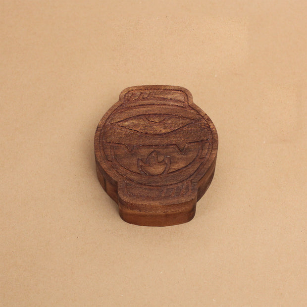 Die cut wooden box, shaped like a lantern with a partially opened eye and mouth with fangs.
