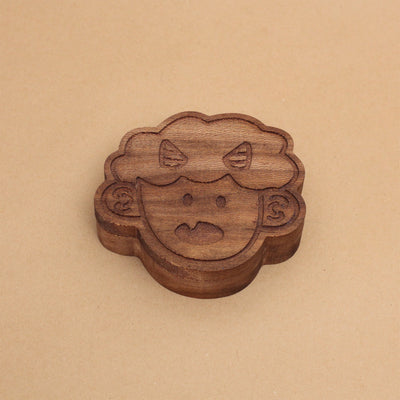 Die cut wooden box of a small, cute child's head with 2 horns and a tiny fang.