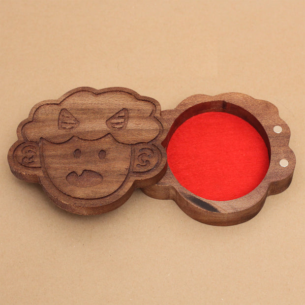 Die cut wooden box of a small, cute child's head with 2 horns and a tiny fang. Lid slides off to reveal a red felt liner.
