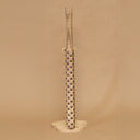 Wooden bat with black metal bumps evenly atop the surface, on a beige background