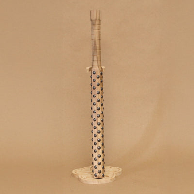 Wooden bat with black metal bumps evenly atop the surface, on a beige background