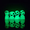 Wooden glow in the dark die cut sculpture of Kodamas, white ghost spirits from Princess Mononoke with circular eyes and open smiles or mouth expressions. They stand side by side, 4 in total.