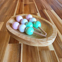 Wooden bowl with 3 sticks of Dango, a popular Japanese dessert comprising of 3 mochi balls (pink, white and green) on each stick.