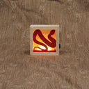 Small wooden shadowbox being illuminated by a warm light in the back. A red snake fits inside of the box, where the light shines behind it.