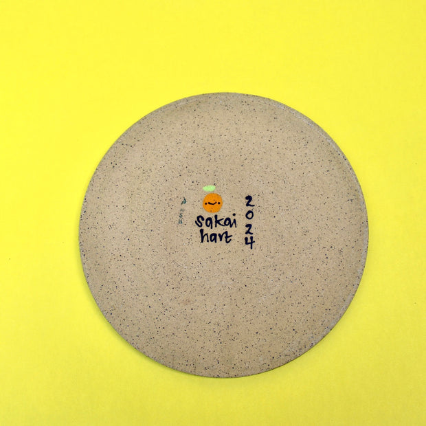 Back of ceramic plate, with artist's signature and the year 2024.