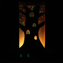 Wooden sculpture contained in a back lit box of a tree, with many small cute ghostly characters (kodamas) peeking out. 