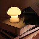 Mushroom-shaped night light on a stack of books with a dark background