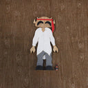 Wooden toy figure of a character with a head shaped like the Big Boss Robot, wearing an untucked white shirt, gray slacks and a red tie around its head instead of its neck.