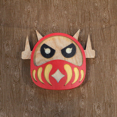 Wooden falt sculpture shaped like a Daruma doll with the head of a Big Boss Robot.