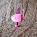 Whittled wooden sculpture of a pink Ocean Sunfish with a happy expression, standing on thin legs with pink shoes.