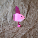 Whittled wooden sculpture of a pink Ocean Sunfish with a happy expression, standing on thin legs with pink shoes.