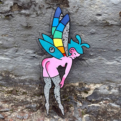 Colorful painting on die cut acrylic sheet of a pink fairy, bending over and smiling. She is nude aside from thigh high sparkly boots and colorful wings.