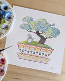 Illustration of a bonsai tree with in a My Neighbor Totoro themed patterned planter. Totoro stands on the green moss at the base of the tree.