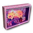 Painting in a pink wooden shadowbox frame of an orange and pink cat, resting in a tiny dollhouse bedroom with a streak of sunlight shining behind it. On the floor of the inner frame are many small doll pieces, all pink and purple in coloring and a tiny mouse sleeping in the doll bed.