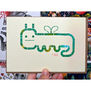 Block print of a worm character with a cartoon face and tiny wings.