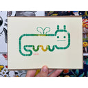 Block print of a worm character with a cartoon face and tiny wings.