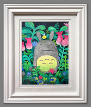 Illustration of a very stylized Totoro, with tiny dots for eyes, standing amongst colorful foliage. Framed.