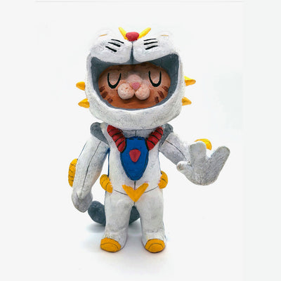 Sculpture of an orange cartoon tabby cat, dressed as a Evangelion style mech, in a white spacesuit with red, yellow and blue accessories.