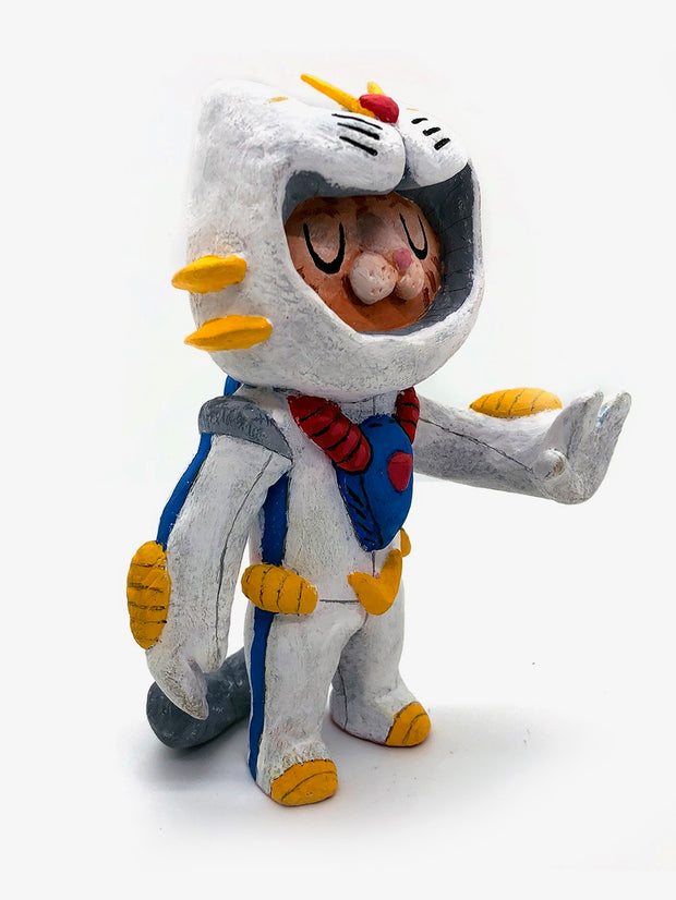 Sculpture of an orange cartoon tabby cat, dressed as a Evangelion style mech, in a white spacesuit with red, yellow and blue accessories. Its hand is extended out, fingers spread.