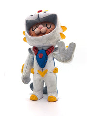 Sculpture of an orange cartoon tabby cat, dressed as a Evangelion style mech, in a white spacesuit with red, yellow and blue accessories. Its hand is extended out, fingers spread.