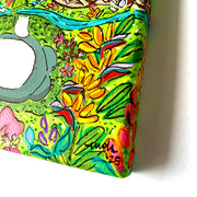 Colorful painting of Totoro, resting amongst Hawaiian foliage.