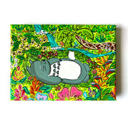 Colorful painting of Totoro, resting amongst Hawaiian foliage.