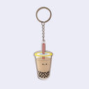Die cut acrylic keychain of an illustrated milk tea boba cup with a small smiling cartoon style face in the center of the cup.