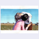 Two people embracing in a field with a clear blue sky.