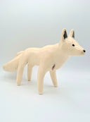 White ceramic fox figurine on a light gray background