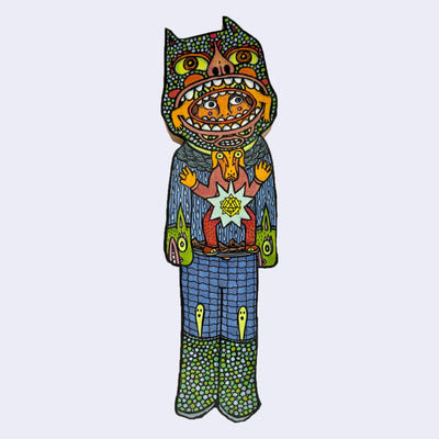 Illustration made with many lines, giving it the feel of a folk art woodcut on a die cut wood panel of a person wearing knit clothing with a mask around their head of a monster, who in turn has a mask around *their* head of a different monster. 