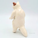 White ceramic cat figurine on a light gray background