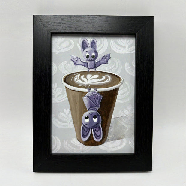 Painting of 2 cartoon style purple bats, positioned around a brown to go coffee cup with latte art. One bat stands on the cup lip and the other hangs upside down off the front.