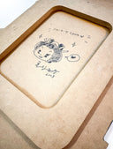 Hand-drawn illustration of a cartoon character on a MDF cut surface