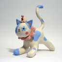Ceramic figurine of a white cat with blue spots, wearing a pink ruffled collar, a small clown hat with clown makeup.