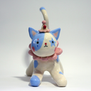 Ceramic figurine of a white cat with blue spots, wearing a pink ruffled collar, a small clown hat with clown makeup.