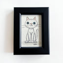 Framed illustration of a small white cartoon cat.