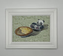 Framed illustration of a panda bear sitting in a mini pie tin, with an egg tart in a mini pie tin in front of it. Background is green with a faint repeating pattern of pandas.