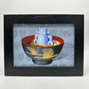 Painting of a blue robot doll in a bowl of miso soup. Interior of the bowl is red and exterior is black with gold cranes. Piece is framed.