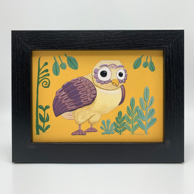 Painting of a cartoon style yellow owl with purple wings and feet, against a solid ochre background with some greenery around. Piece is framed in thick wooden frame.